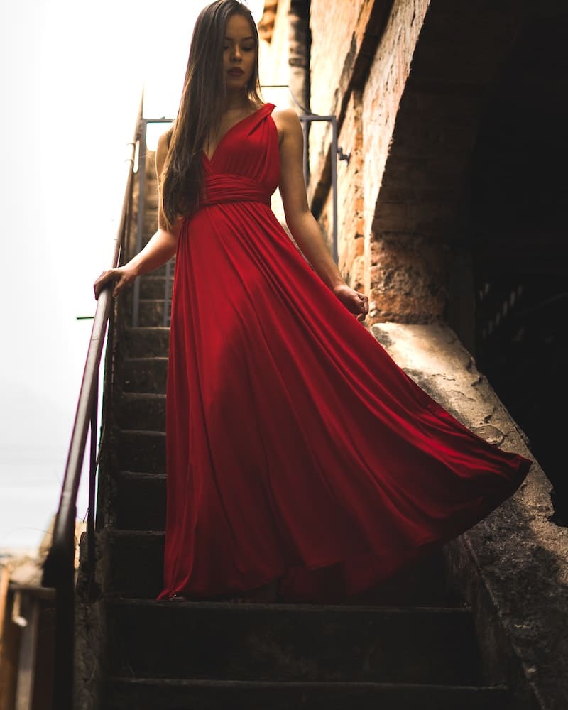 mulher descendo escadas com vestido vermelho